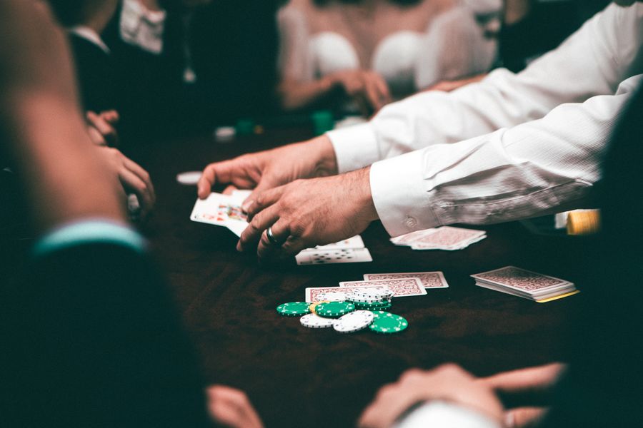 Pemain memegang kartu poker di atas meja penuh chip